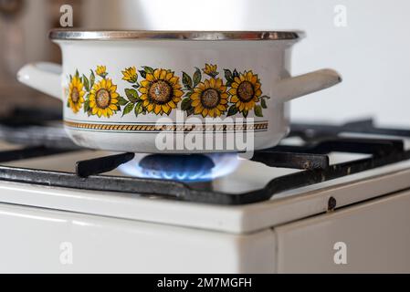 Die Flamme eines alten Gasherds brennt in einer Küche. Stockfoto