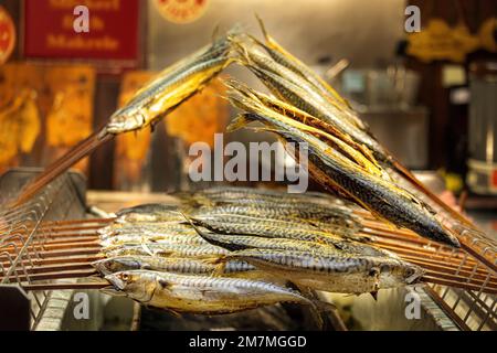 Stecken Sie Fisch auf den Grill Stockfoto