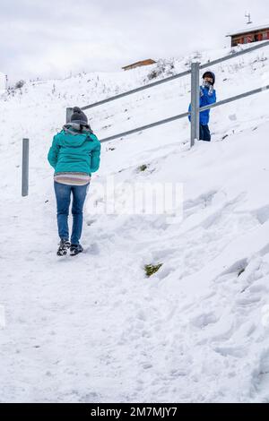 Europa, Deutschland, Süddeutschland, Bayern, Oberbayern, Bayerische Alpen, Lenggries, Mutter und Sohn, die im Schnee unter dem Brauneck Gipfelhaus spielen Stockfoto