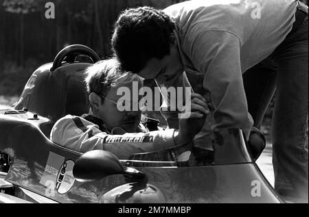 CPT Craig Higgins, Leiter der Auftragsprogrammierung für die 52. Bauingenieurstaffel, wird von seinem Crewchef SGT Fred Venecia unterstützt, bevor er auf einer Straße in der Nähe des Stützpunkts eine Probefahrt mit seinem Formel-Ford-Royale-Rennwagen durchführt. Basis: Luftwaffenstützpunkt Spangdahlem Land: Westdeutschland (FRG) Stockfoto