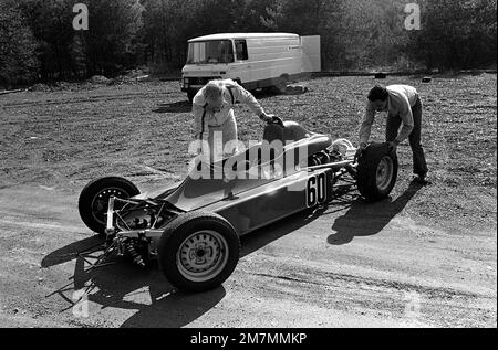 CPT Craig Higgins, Leiter der Auftragsprogrammierung für die 52. Bauingenieurstaffel, wird von seinem Crewchef SGT Fred Venecia unterstützt, bevor er auf einer Straße in der Nähe des Stützpunkts eine Probefahrt mit seinem Formel-Ford-Royale-Rennwagen durchführt. Basis: Luftwaffenstützpunkt Spangdahlem Land: Westdeutschland (FRG) Stockfoto