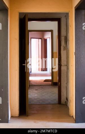 Wohnungseingang in einem heruntergekommenen Wohnungsgebäude in Deutschland Stockfoto