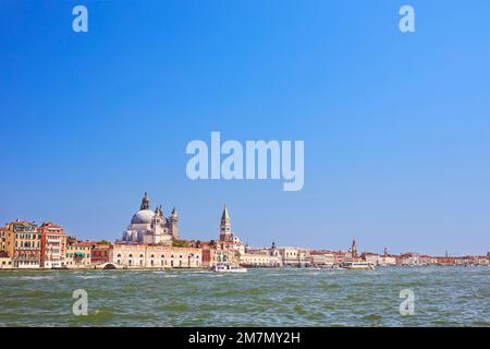 Direkt am Canale Grande befindet sich die barocke Kirche Santa Maria della Salute, erbaut von 1631 von Baldassare Longhena, 1687 geweiht, nicht weit entfernt vom Dogenplatz und dem frei stehenden Glockenturm Campanile di San Marco Stockfoto