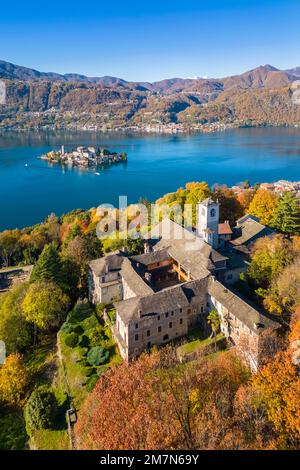 Blick aus der Vogelperspektive auf den Sacro Monte von Orta und die Insel San Giulio am Orta-See im Herbst. Orta Lake, Provinz Novara, Piedmont, Italien. Stockfoto