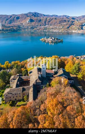 Blick aus der Vogelperspektive auf den Sacro Monte von Orta und die Insel San Giulio am Orta-See im Herbst. Orta Lake, Provinz Novara, Piedmont, Italien. Stockfoto