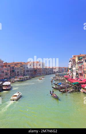 Ein Motorboot und eine Gondelfahrt nebeneinander auf dem Canale Grande in Venedig Stockfoto