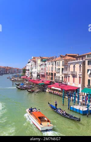 Ein Motorboot und eine Gondelfahrt nebeneinander auf dem Canale Grande in Venedig Stockfoto