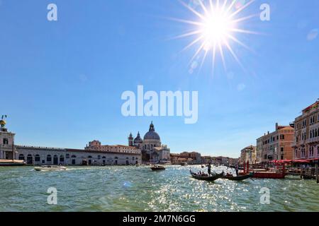 Gondeln bringen Touristen auf dem Canale Grande in Venedig an Häusern vorbei, gegelichtaufnahme Stockfoto