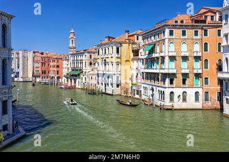 Ein Motorboot und eine Gondel fahren entlang des Canal Grande vorbei an herrlichen Häusern Stockfoto