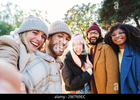 Eine Gruppe junger Leute, die lächeln und Spaß haben, Selfie-Porträts zu machen. Fünf Multirassenfreunde, die in die Kamera schauen. Lustige Outdoor-Aktivitäten von fröhlichen Schülern fern von zu Hause. Lifetyle-Konzept. Hochwertiges Foto Stockfoto