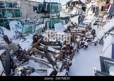 Demontierte Fahrzeuge auf einer Abkippstelle sind als Ersatzteile erhältlich. Ein Stapel Gläser, Hängebügel und Türen. Der Handel mit gebrauchten Ersatzteilen ist ein gängiges Geschäft Stockfoto