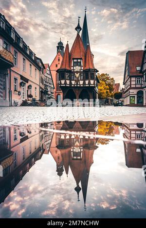 Historisches Rathaus mit Marktplatz, Fachwerkhaus mit Reflexion in einer Pfütze, Michelstadt, Hessen, Deutschland Stockfoto