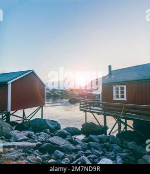 Nusfjord, Sonnenuntergang über den Bergen, Angelhütte, Fischerdorf, Lofoten, Nordland, Norwegen Stockfoto