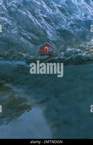 Nusfjord, abendliche Atmosphäre, beleuchtete einsame Hütte, Fischerdorf, Lofoten, Nordland, Norwegen Stockfoto