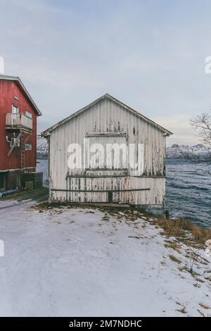 Altes Holzboathouse, weiß gestrichen, abblätternde Farbe von altem Gebäude, Nordland, Norwegen Stockfoto