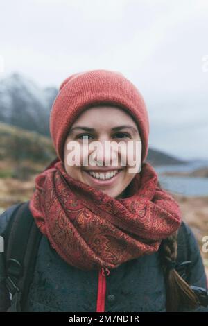 Portrait einer glücklichen jungen Frau, die in Vesteralen, Norwegen wandert, selbstbewusst, lachend, Stockfoto