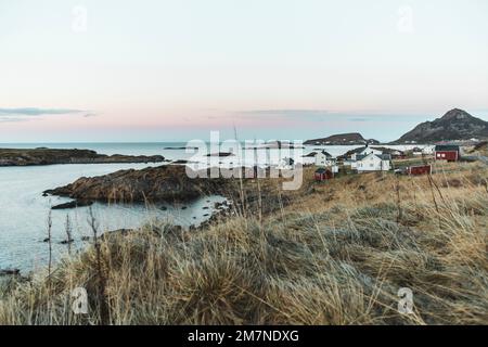 Abgelegenes Fischerdorf mit typischen nordischen Hütten und Häusern in abendlicher Atmosphäre, Fjordlandschaft mit kleinen Inseln, Abgeschiedenheit von der Außenwelt, Vesteralen, Norwegen Stockfoto