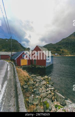 Einsames Fischerhäuschen am Fjord in Norwegen, typische Fjordlandschaft mit kleinen Inseln, abgeschieden von der Außenwelt, Haus am See Stockfoto