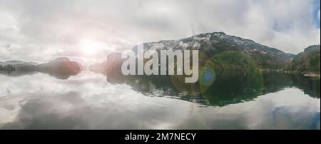 Panoramabild mit einer Gruppe von Inseln, Bergen und Meer in Norwegen, Landschaft mit Sonnenstrahlen, typische Fjordlandschaft mit kleinen Inseln, Skandinavien Stockfoto