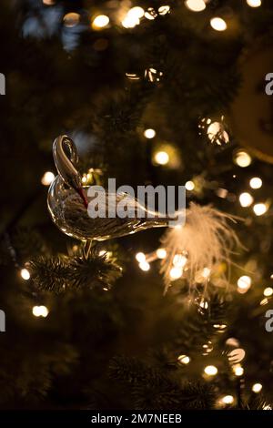 Weihnachtsbaumfigur in Form eines Schwans im beleuchteten Weihnachtsbaum Stockfoto