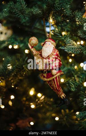 Weihnachtsbaumfigur in Form des Weihnachtsmanns in beleuchtetem Weihnachtsbaum Stockfoto
