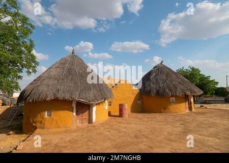 Jaisalmer, Rajasthan, Indien - 15. Oktober 2019 : bunte Hütten im Dorf Rajsathani, Jaisalmer, Indien. Blauer Himmel und weiße Wolken Hintergrund. Stockfoto