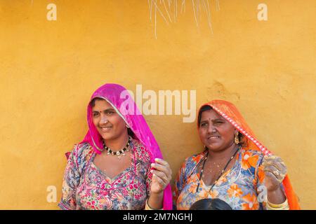 Jaisalmer, Rajasthan, Indien - 15. Oktober 2019 : lächelnde und glückliche Rajasthani-Frauen in lokalen Kostümen, die sich in einem Rajasthani-Dorf posieren. Stockfoto