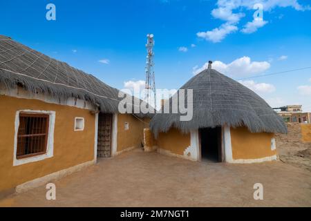 Jaisalmer, Rajasthan, Indien - 15. Oktober 2019 : bunte Hütten im Dorf Rajsathani, Jaisalmer, Indien. Blauer Himmel und weiße Wolken Hintergrund. Stockfoto