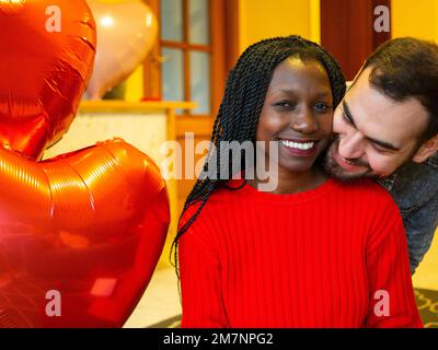 Porträt eines gemischtrassigen Paares, das sich umarmt und den Valentinstag genießt Stockfoto