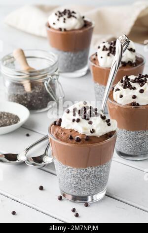 Schokoladenmousse Chia Pudding Snacks garniert mit Schlagsahne und Schokoladenbällchen. Stockfoto