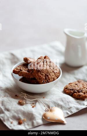 Hausgemachte Kekse mit Müsli und Samen, Schüssel auf einem Tisch, Seitenansicht Stockfoto