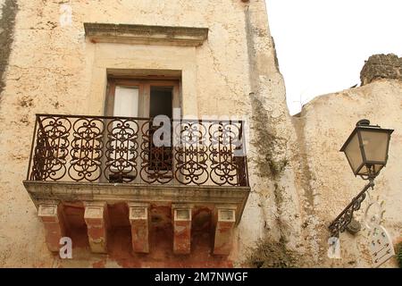 Gebäude mit kleinem Balkon mit Steinkorbeln im historischen Zentrum von Racale, Italien Stockfoto