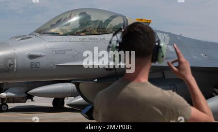 Captain Taylor Ham, 14. Fighter Squadron F-16C Fighting Falcon Pilot, gibt Startbereitschaft an Senior Airman Destin Johnson, 14. Aircraft Maintenance Unit Crew Chief, im Rahmen einer einwöchigen Agile Combat Employment Training Übung, die darauf abzielt, die Fähigkeiten multifähiger Airmen am Yokota Air Base, Japan, zu verbessern, Mai 11, 2022. Yokota Airmen, die Schnellluftkräfte praktizierten, bewarben vier C-130Js der 36. Airlift Squadron, die von acht F-16Cs der 14. Fighter Squadron, Misawa Air Base, Japan, begleitet wurden, in einer gemeinsamen Airdrop-Trainingsmission. Während des ACE Stockfoto