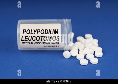 Das Konzept von Pharmakologie und Gesundheit. Auf einer blauen Oberfläche befinden sich Pillen und ein staubiges Gefäß mit der Aufschrift - Polypodium Leucotomos Stockfoto