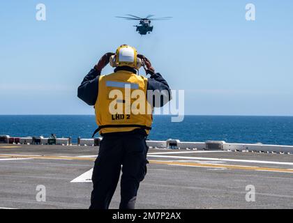 PACIFIC OCEAN (11. Mai 2022) Aviation Boatswain's Mate (Handling) Airman Corey Martin, ein Einheimischer aus Jacksonville, Florida, signalisiert an einen CH-53D Sea Hallion, angeschlossen an Marine Heavy Helicopter Squadron (HMH) 462, an Bord des Amphibienschiffs USS Essex (LHD 2), 11. Mai 2022. Essex führt gerade Routineeinsätze in der US-3.-Flotte durch. Stockfoto