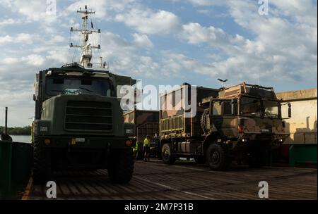 Ein australischer Army MAN 40m Truck, beladen mit Wasseraufbereitungssystemen (rechts), der dem 1. Combat Engineer Regiment, 1. Field Squadron, gehört, wird auf einem Lastkahn neben einem U.S. Marine Corps Medium Tactical Vehicle Replacement, der dem Logistics Command Element, Marine Rotational Force-Darwin (MRF-D) 22 gehört, Während einer kombinierten logistischen Bewegung von Geräten für Übung Crocodile Response 22 in Darwin, NT, Australien, 12. Mai 2022. MRF-D 22 und Ausrüstung der Australischen Armee wurden auf zivile Lastkähne für den Transport verladen, was die Flexibilität bei der Durchführung humanitärer Hilfe und di demonstriert Stockfoto