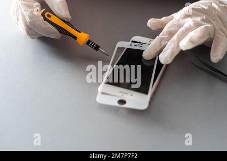 Smart Solution Technologiekonzept. Zugeschnittener Fotoersatz von Schutzfolie durch einen neuen. Man entfernt vorsichtig das alte Schutzglas aus dem Stockfoto