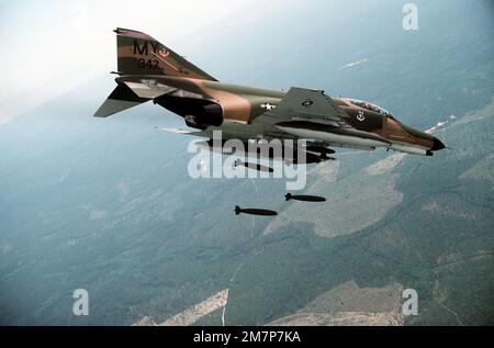 Eine Air-to-Air-Seitenansicht eines F-4E Phantom II Flugzeugs, das sechs Mark 82 500-Pfund-Bomben mit geringem Luftwiderstand über eine Reichweite abwirft. Das Flugzeug trägt einen zusätzlichen Treibstofftank auf jedem Flügel. Das Flugzeug ist dem 347. Taktischen Kampfflugflügel zugewiesen. Basis: Luftwaffenstützpunkt Nellis Bundesstaat: Nevada (NV) Land: Vereinigte Staaten von Amerika (USA) Stockfoto