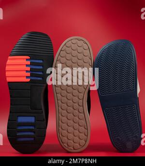 Verschiedene Sohlenmotive auf rotem Studiohintergrund Stockfoto