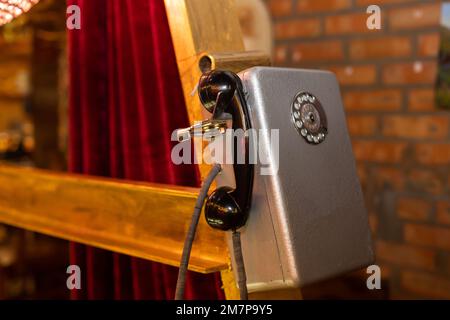 Das alte graue Payphone mit Spot für Telefonempfänger aus der Nähe Stockfoto