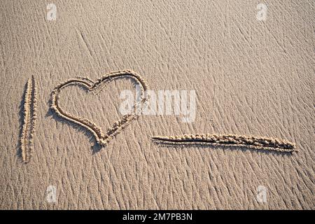 Ich liebe Herzbotschaften, handgeschrieben in sauberem Sand mit Platz für Text am Strand Stockfoto