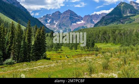 Maroon Creek Valley - Sommeransicht der Maroon Bells, die hoch am Ende des üppig grünen Maroon Creek Valley aufragen. Aspen, Colorado, USA. Stockfoto