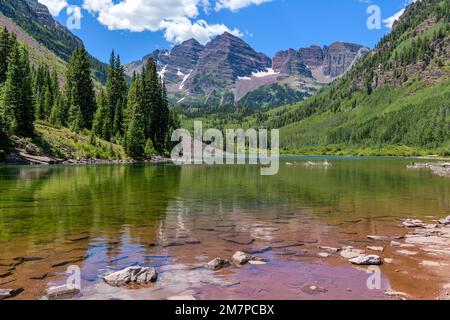 Kastanienbraune Glocken und Maroon Lake - Weitwinkelblick auf die kastanienbraunen Glocken am Maroon Lake an einem sonnigen Sommertag. Aspen, Colorado, USA. Stockfoto