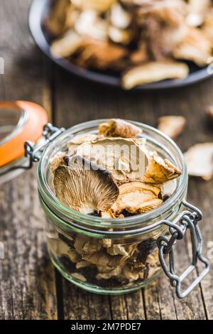 Geschnittene getrocknete Pilze im Glas auf dem Holztisch. Stockfoto