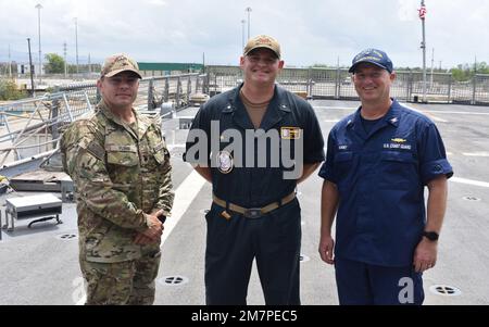 220511-N-N3764-1004 PONCE, Puerto Rico - (11. Mai 2022) - Cmdr. Brett Seeley, kommandierender Offizier des Kampfschiffs USS Billings (LCS 15) Gold der Freiheitsvariante, posiert für ein Foto mit Kapitän Robert ‚Bob‘ Kinsey, Chief, Response Enforcement Branch Seventh Coast Guard District (rechts) und Commander. Frank Florio, Befehlshaber des taktischen Strafverfolgungskommandos (TACLET) South (links), während einer Rundfahrt durch das Schiff, 11. Mai 2022. Billings wird in das US-Flottengebiet 4. entsandt, um die Mission der Joint Interagency Task Force South zu unterstützen, die auch die Bekämpfung des illegalen Drogenhandels umfasst Stockfoto