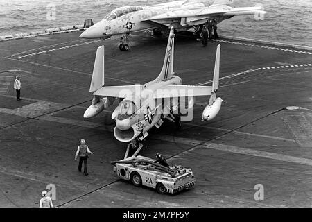 Mitglieder der Flugzeugumschlagbesatzung verwenden einen Schlepper MD-3A, um ein Flugzeug Der Klasse A-7E Corsair während des Flugbetriebs an Bord des nukleargetriebenen Flugzeugträgers USS DWIGHT D. EISENHOWER (CVN-69) an einen Parkplatz zu bringen. Die A-7E ist dem Light Attack Squadron 66 (VA-66) zugewiesen. Basis: USS Dwight D Eisenhower (CVN 69) Stockfoto