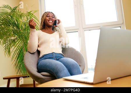 afroamerikanische Frau mit angenehmen Gespräch per Handy mit Freund Stockfoto