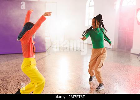 Bild einer Gruppe von zwei glücklichen, vielfältigen Hip-Hop-Tänzerinnen im Studio Stockfoto