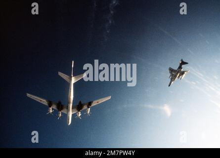 Eine Luft-Luft-Ansicht von unten eines sowjetischen TU-95 Bear-Flugzeugs, links, wird von einem US-Bürger beobachtet Air Force F-4 Phantom II über internationalen Gewässern. Land: Nordatlantik Stockfoto