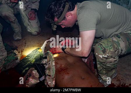 Ein Green Beret mit 10. Special Forces Group (Airborne) überprüft während eines Trainingsszenarios in Fort Carson, Colorado, Mai 11 2022, auf einen Puls bei einem Verletzten. Die Schulung zur taktischen Kampfnotfallversorgung bestand aus interaktiven Bahnen, auf denen die Teilnehmer in Echtzeit auf Unfallszenarien reagierten. Stockfoto